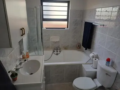 a bathroom with a tub and a toilet and a sink at Greens Golf Course Apartment in De Grendel
