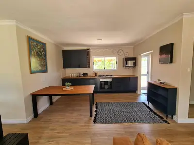 a kitchen with a wooden table in a room at Kuku House in Cape Town