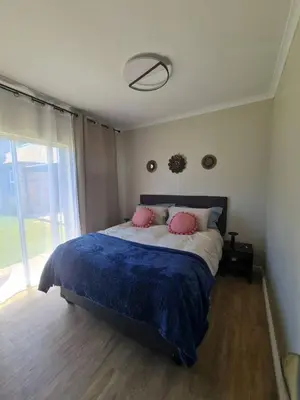 a bedroom with a large bed with two pink pillows at Kuku House in Cape Town