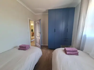 two beds in a room with a blue cabinet at Kuku House in Cape Town