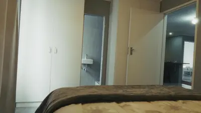 a bedroom with a bed and a walk in shower at Halaal Serenity 3bedroom 6sleeper in Cape Town