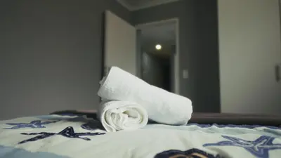 a roll of white towels sitting on top of a bed at Halaal Serenity 3bedroom 6sleeper in Cape Town