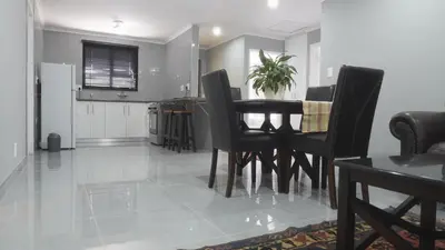 a dining room and living room with a table and chairs at Halaal Serenity 3bedroom 6sleeper in Cape Town