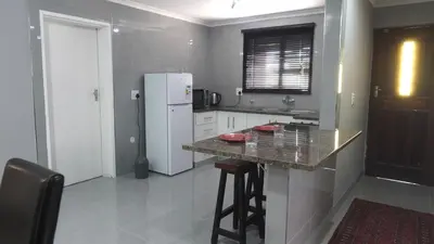 a kitchen with a white refrigerator and a counter at Halaal Serenity 3bedroom 6sleeper in Cape Town