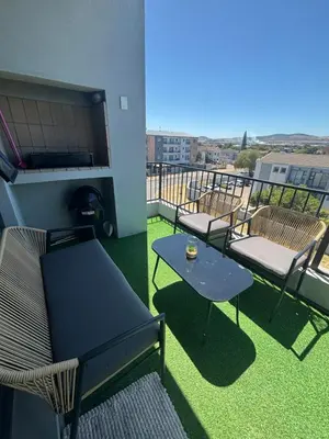 a balcony with chairs and a table on a balcony at Tranquil Luxe Retreat in Cape Town