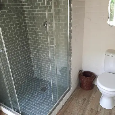 a bathroom with a glass shower with a toilet at Bobbejaanskloof in Bettyʼs Bay