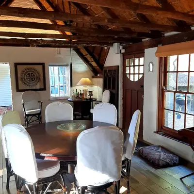 a dining room with a table and white chairs at Bobbejaanskloof in Bettyʼs Bay