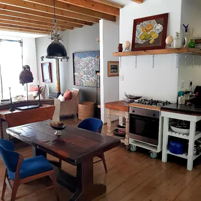 a living room with a table and a stove at Bobbejaanskloof in Bettyʼs Bay