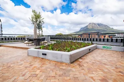 a patio with a table and a view of a mountain at 723 Riverlands - Lux 1 bedroom Apartment in Cape Town