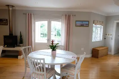 a dining room with a white table and chairs at Sipres Garden in Durbanville
