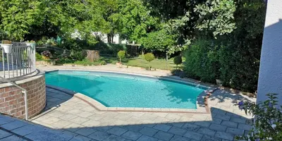 a swimming pool in a yard with a brick fence at Sipres Garden in Durbanville