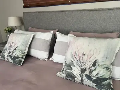 a group of pillows sitting on a bed at Sipres Garden in Durbanville