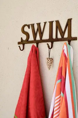 two towels hanging on a rack with the word swim at Sipres Garden in Durbanville