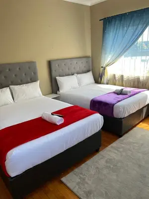 a bedroom with two beds and a window at Ridah's Accomodation in Bellville