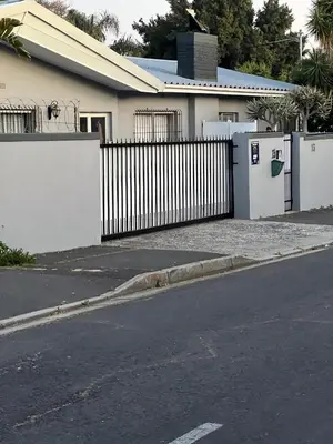 a white fence in front of a house at Ridah's Accomodation in Bellville