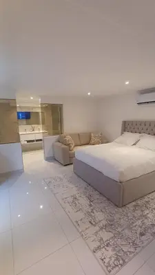 a bedroom with a large bed and a couch at Cherrywood Guest House in Cape Town