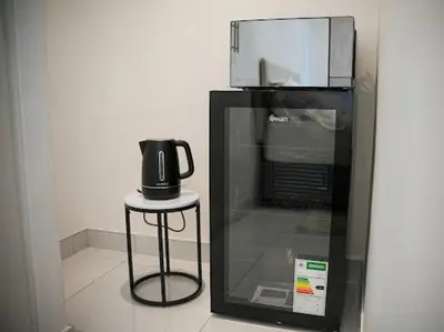 a coffee pot sitting on a stool next to a microwave at Cherrywood Guest House in Cape Town