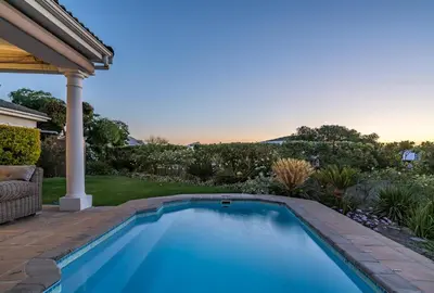 a swimming pool in the backyard of a house at Cheerful 4 bedroom home with pool & wonderful view in Somerset West