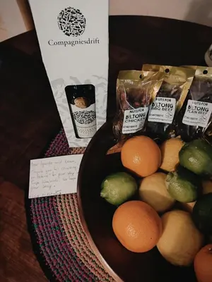 a bowl of fruit on a table next to a box of food at The Palm's on Pastorie in Pniel