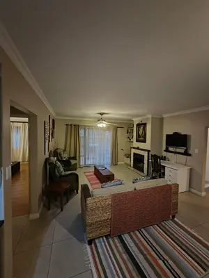 a living room with a couch and a tv at The Palm's on Pastorie in Pniel