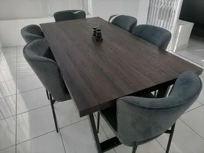 a wooden table with blue chairs around it at Townhouse in Bloubergstrand in Cape Town