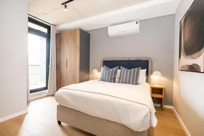 a bedroom with a large bed and a window at 510 Riverlands - Lux 1 bedroom Apartment in Cape Town
