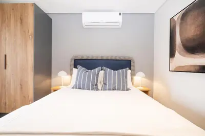 a bedroom with a white bed with two lamps at 510 Riverlands - Lux 1 bedroom Apartment in Cape Town