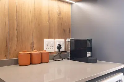 a kitchen counter with a coffee maker and a microwave at 510 Riverlands - Lux 1 bedroom Apartment in Cape Town