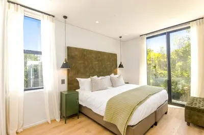 a bedroom with a bed and a large window at Stylish Apartment in Cape Winelands District in Stellenbosch