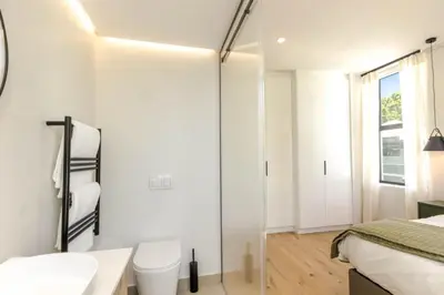 a white bathroom with a toilet and a sink at Stylish Apartment in Cape Winelands District in Stellenbosch