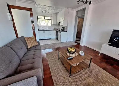 a living room with a couch and a table at Villa d'aqua in Cape Town