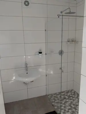 a bathroom with a sink and a glass shower at Rihla Residences - Hanbury Road in Cape Town