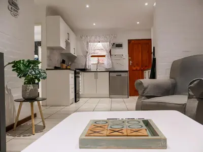 a kitchen and a living room with a table at Gulls Nest in Hermanus