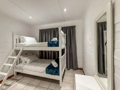 a small room with two bunk beds in it at Gulls Nest in Hermanus