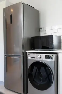a kitchen with a stainless steel refrigerator and a microwave at CAG The Alxndr Stellenbosch in Stellenbosch