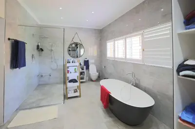 a bathroom with a tub and a shower and a sink at Garden Pool Manor House in Kuilsrivier