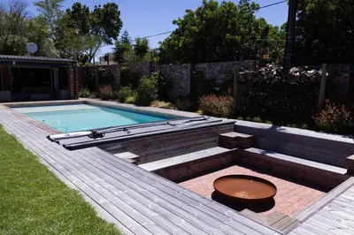 a pool with a bench and a table in a yard at Garden Pool Manor House in Kuilsrivier