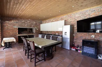 a kitchen with a table and a brick wall at Garden Pool Manor House in Kuilsrivier