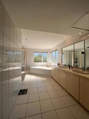a large white bathroom with two sinks and mirrors at 2 on Aurora Island in Durbanville