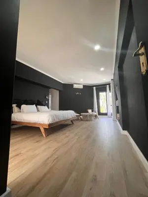 a bedroom with a large bed and a wooden floor at 2 on Aurora Island in Durbanville