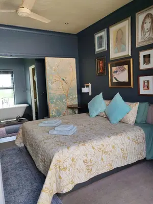 a bedroom with a large bed with blue walls at Franschhoek Guest Suite in Franschhoek
