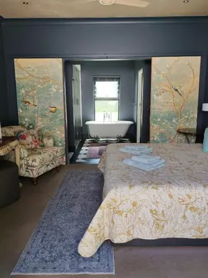 a bedroom with a large bed and a bath tub at Franschhoek Guest Suite in Franschhoek