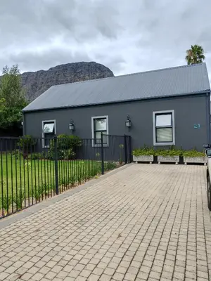 a gray house with a fence in front of it at Franschhoek Guest Suite in Franschhoek