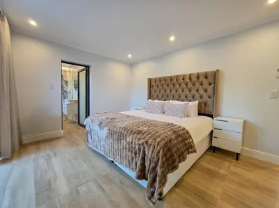 a bedroom with a large bed with a large headboard at 12 Sleeper Luxury Villa Chaffinch in Cape Town