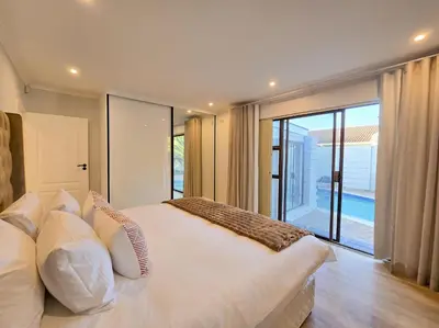a bedroom with a large white bed and a large window at 12 Sleeper Luxury Villa Chaffinch in Cape Town