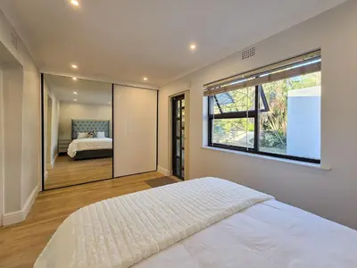 a bedroom with a bed and a large window at 12 Sleeper Luxury Villa Chaffinch in Cape Town