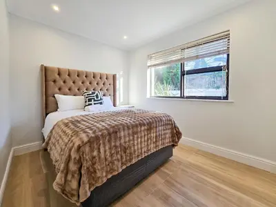 a bedroom with a large bed and a window at 12 Sleeper Luxury Villa Chaffinch in Cape Town