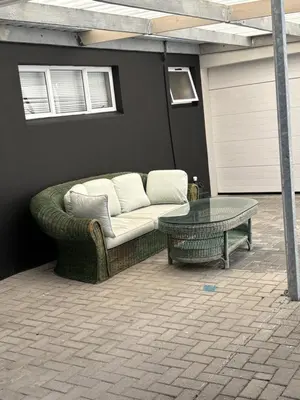 a couch and a table on a patio at Home Away From Home 6 minutes away from beach in Cape Town