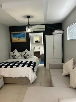 a bedroom with a bed and a couch at Home Away From Home 6 minutes away from beach in Cape Town