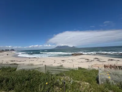 a beach with a view of the ocean and mountains at Home Away From Home 6 minutes away from beach in Cape Town